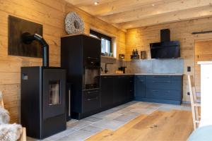 a kitchen with black cabinets and blue counters at Bayerwald Chalet Liebenstein in Bad Koetzting