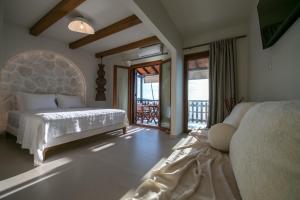 ein Schlafzimmer mit Bett und Balkon in der Unterkunft ARGO Luxury Suites in Milína