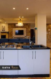 a kitchen with a sink and a living room at Villa Saya Jerash in Jerash