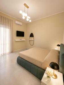 a bedroom with a bed and a couch and a television at Rachele Boutique Apartments in Agropoli
