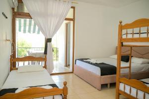 a bedroom with two bunk beds and a balcony at Noa Hotel Velipoje in Velipojë