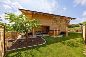 a backyard with a house with a tree at Bayerwald Chalet Liebenstein in Bad Koetzting