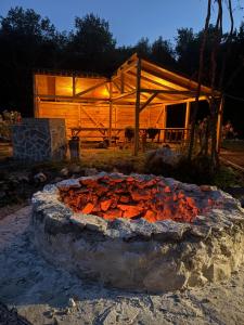 a fire pit in front of a wooden building at Wilgano in Rvaši