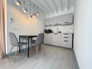 a kitchen with a table and two chairs at Sunset House Svencele in Svencelė
