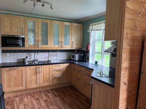 a kitchen with wooden cabinets and black counter tops at Feriehus Lærdal in Æri +11 photos