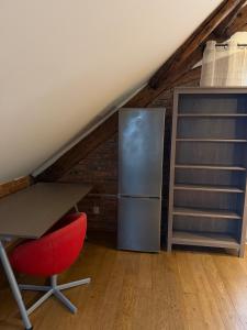 a kitchen with a refrigerator and a table and a red chair at Timber City Loft in Slezská Ostrava +10 photos