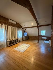 a large living room with wooden floors and a tv at Timber City Loft in Slezská Ostrava