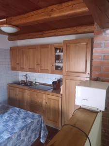 a kitchen with wooden cabinets and a box on a table at La casetta di Marmora in Marmora