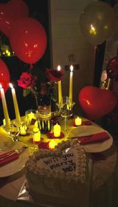 a birthday cake on a table with candles and balloons at Yellow House Natakhtari in Mtskheta +41 photos