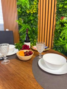 a table with plates and bowls of fruit and a bottle of wine at DIAMOND MIRAGE Militari Residence in Chiajna