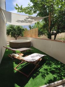 a patio with two lounge chairs on the grass at Casa El Nacimiento in Guadix