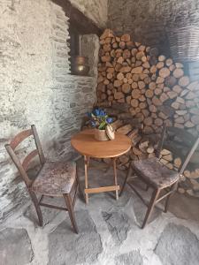 a table and two chairs in a room with a pile of wood at La casetta di Marmora in Marmora +14 photos