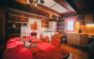 a kitchen with a wooden table and red chairs at Chata Reľov in Reľov