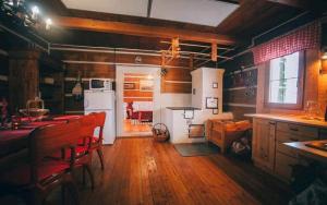a kitchen with wooden floors and a kitchen with white appliances at Chata Reľov in Reľov +6 photos