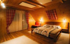 a bedroom with a bed in a wooden room at Chata Reľov in Reľov