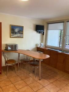 a kitchen with a wooden table and some chairs at Rusałka Domki Rodzinne in Rudno