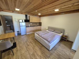 a bedroom with a bed and a table and a refrigerator at Apartma Markelj in Radovljica