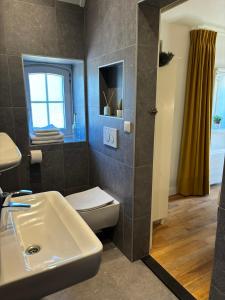 a bathroom with a sink and a toilet and a window at Recreatieappartement BoerdeRijlst - De Winkel in Sint Nicolaasga