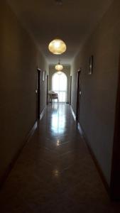 an empty hallway with a table and a light fixture at Gozo Apartment - Sannat in Sannat +2 photos