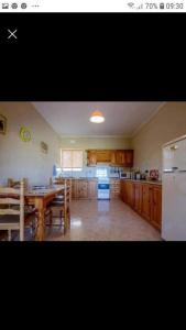 a kitchen with a table and a kitchen with a refrigerator at Gozo Apartment - Sannat in Sannat