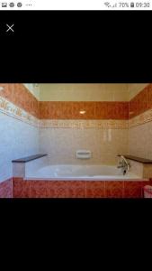 a bath tub in a bathroom with a sink at Gozo Apartment - Sannat in Sannat