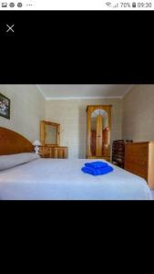 a bedroom with a bed with a blue pillow on it at Gozo Apartment - Sannat in Sannat