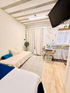 a room with a bed and a table and a tv at Zion Cottage in Paraty