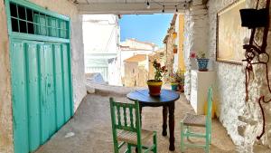an alley with a table and chairs and a green door at Casa Amigos Sorvilan - Limón in Sorvilán