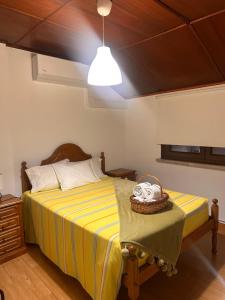 a bedroom with a bed with a yellow and white striped sheets at Casa dos Avós in Geres +25 photos