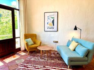 a living room with a blue couch and two chairs at Casa Amigos Sorvilan - Limón in Sorvilán
