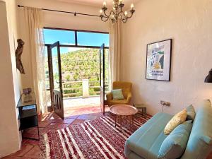 a living room with a blue couch and a large window at Casa Amigos Sorvilan - Limón in Sorvilán