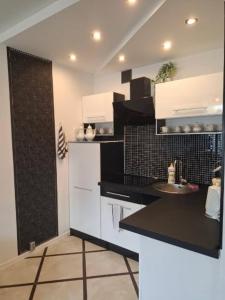 a kitchen with black and white cabinets and a sink at Apartament Glamour in Rybnik