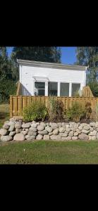 a house with a fence and a pile of rocks at Stuga 2 Björkeslund in Veberöd