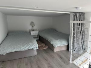 a bedroom with two beds and a ladder at Stuga 2 Björkeslund in Veberöd