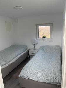 a bedroom with two beds and a window at Stuga 2 Björkeslund in Veberöd