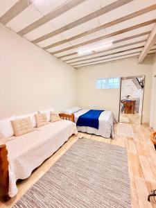 a bedroom with two beds and a rug at Zion Cottage in Paraty