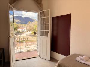 ein Schlafzimmer mit Tür zum Balkon in der Unterkunft Hotel Aleph in Capilla del Monte