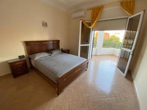 a bedroom with a bed and a sliding glass door at Villa Perle Bleu in Saïdia