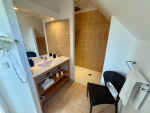 a bathroom with a sink and a mirror at L'Overlord , meublé de tourisme in Colleville-sur-Mer