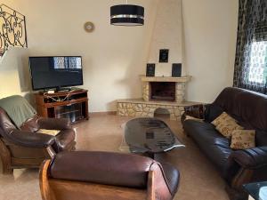 a living room with leather furniture and a television at Villa Perle Bleu in Saïdia