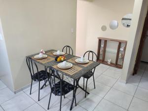 a dining room table with chairs and plates of food on it at Excelente Apartamento in Buíque