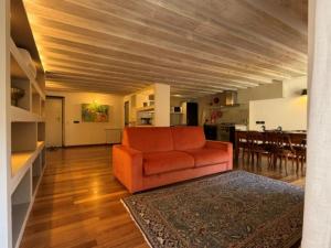 a living room with an orange couch and a kitchen at Luxury Cernaia Home alloggio di charme nel Centro Storico in Genoa