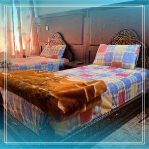 two beds sitting next to each other in a room at Auberge Bab chellalat in Tamarout +17 photos