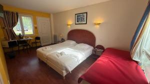 a hotel room with a bed and a red bed sidx sidx sidx sidx at L'Overlord , meublé de tourisme in Colleville-sur-Mer