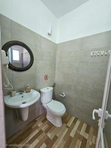 a bathroom with a toilet and a sink at Troi beach house in Vlorë +53 photos