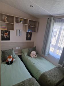 a bedroom with two beds with stuffed animals on them at Riley's Caravan sand le mere tunstall view in Tunstall +13 photos