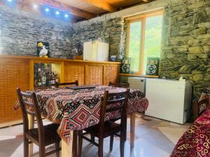 a dining room with a table and a stone wall at Hotel Arkhoti in Akhieli