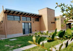 a building with a yard in front of it at La Isolina Chacras, jardín, parrilla y naturaleza! in Chacras de Coria +12 photos