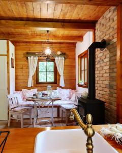 a kitchen with a table and a stove in a room at Căsuța cu Alune in Rîmeţi-Valea Uzei