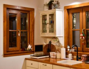 a kitchen with wooden cabinets and a sink at Căsuța cu Alune in Rîmeţi-Valea Uzei +53 photos
